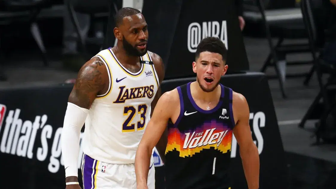 May 23, 2021; Phoenix, Arizona, USA; Phoenix Suns guard Devin Booker (1) reacts alongside Los Angeles Lakers forward LeBron James (23) in the first half during game one in the first round of the 2021 NBA Playoffs. at Phoenix Suns Arena. Mandatory Credit: Mark J. Rebilas-USA TODAY Sports